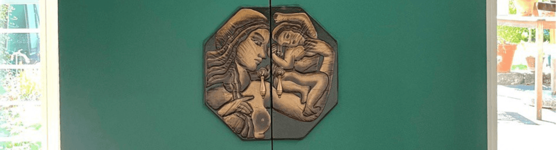 Reliefkunst einer Mutter mit Kind an grüner Wand in der Werkstatt für Schönes Düsseldorf